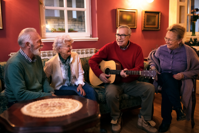 senior men playing guitar with his friends