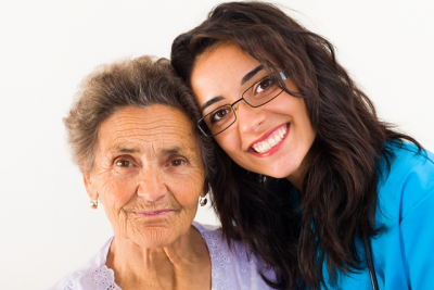 caregiver smiling together with senior woman